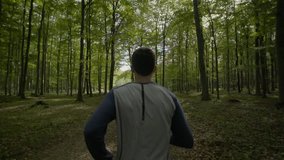 Slow motion video of man running in the woods
