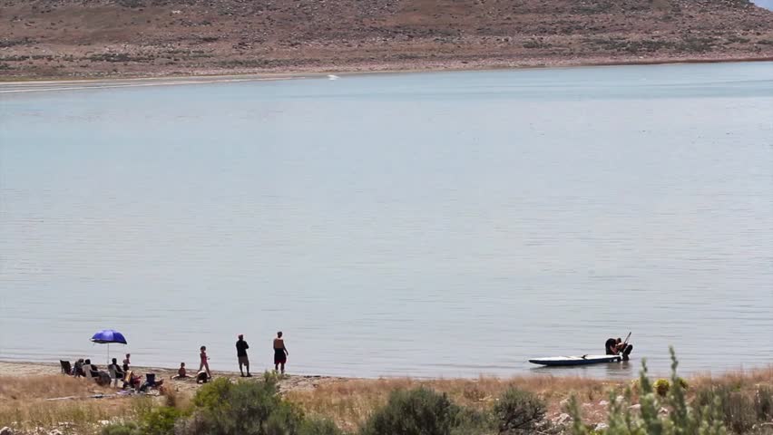 People setting up a small sailboat in the bay