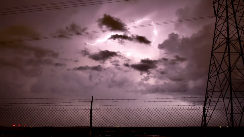 Huge thunderstorm storm with extensive lightning, framed by an electrical tower
