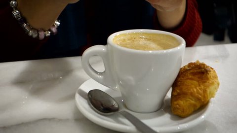 Female Hand Stirring Sugar into coffe latte. Having Morning coffee
