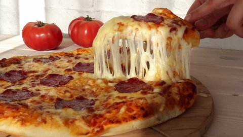 taking slice of pizza with super stretching cheese
