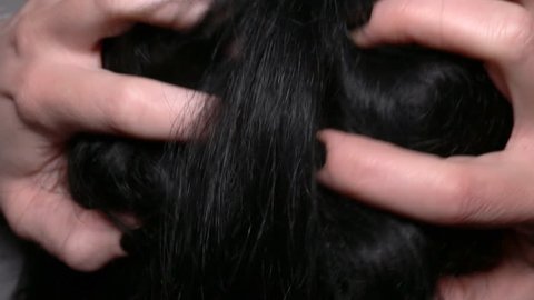 Woman scratching her head with black hair. Macro shot.