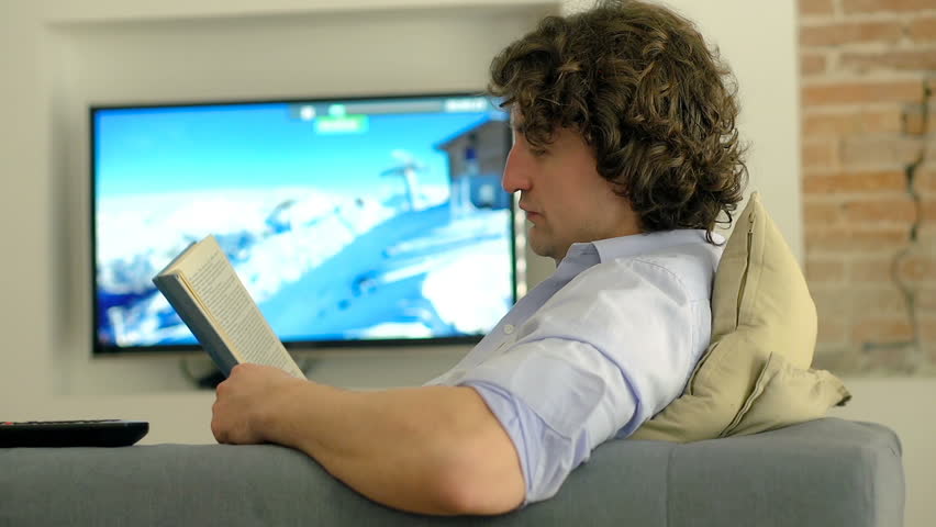 Woman crossing living room while man reading book on the sofa
 | Shutterstock HD Video #23940949