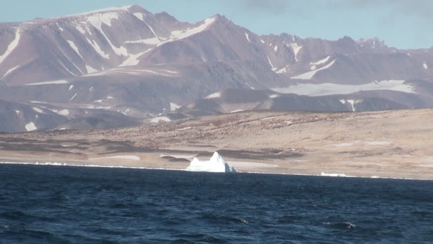 Mountains on shore in mountains on shore of Greenland in Arctic Ocean. Wilderness. Extreme tourism and travel in the cold polar north. Scenic coastline and blue water. Iceland.