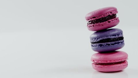 Three colourful macarons, which lay on each other, rotating before the camera