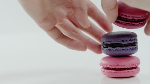 Three colourful macarons, which lay on each other, rotating before the camera
