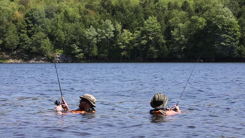 two fisherman casting while in water