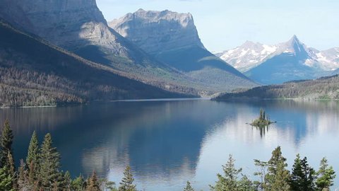 Glacier National Park, Wild Goose Island, St Mary's Lake, Montana, mountain pan. Movement in clouds. Beautiful glacial mountains, lake and forest. Island in lake. Travel destination for vacation.