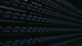 Light beams pass over empty seat rows in large venue. 4K UHD RAW edited footage