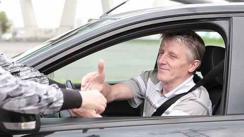 Mature Caucasian man get ignition key sitting in new car, starting and get a move on