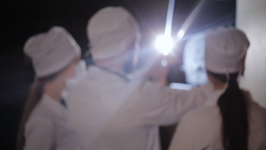 Healthcare, medical: Group of multi-ethnic doctors discuss and looking x-ray in a clinic or hospital