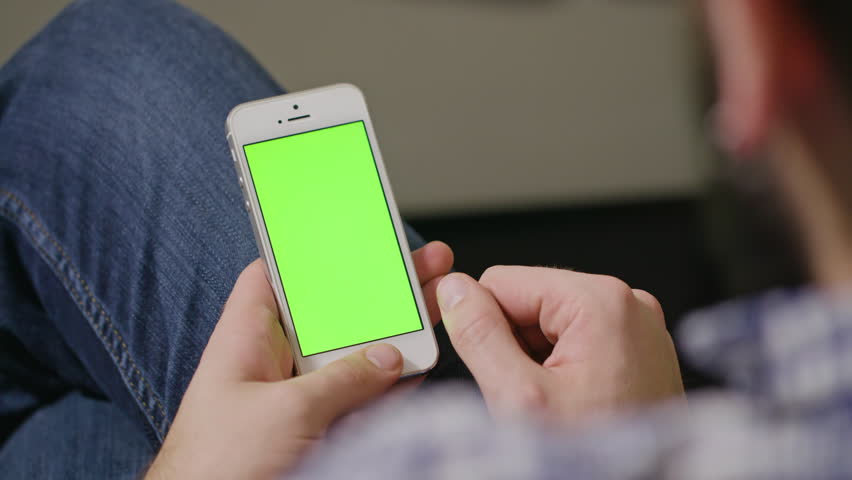 Young man is Holding Phone with green Screen at Home, tap Royalty-Free Stock Footage #23961484