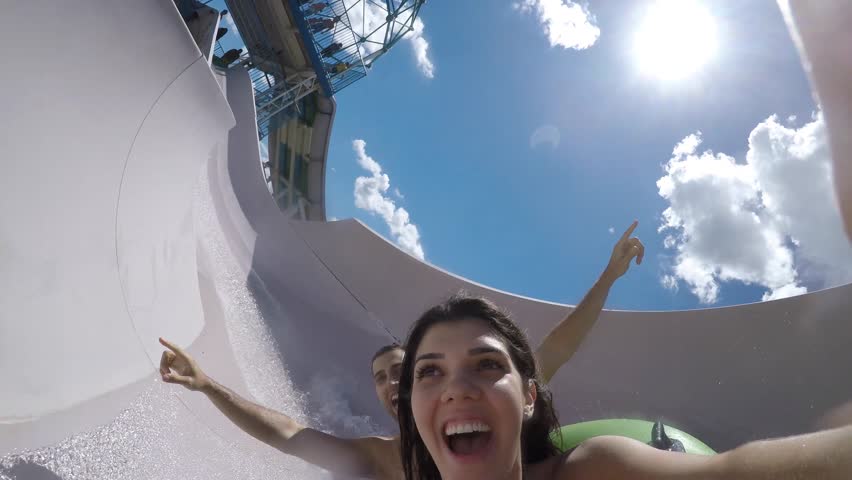 Couple having fun and sliding down in a water slide Royalty-Free Stock Footage #23965447