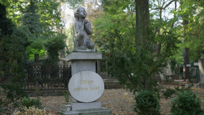 A shot that rotates around a statue of a child pleading for their life in Olsany Cemetery in Prague.  The inscription reads: "Children Victims of War". 4k.
