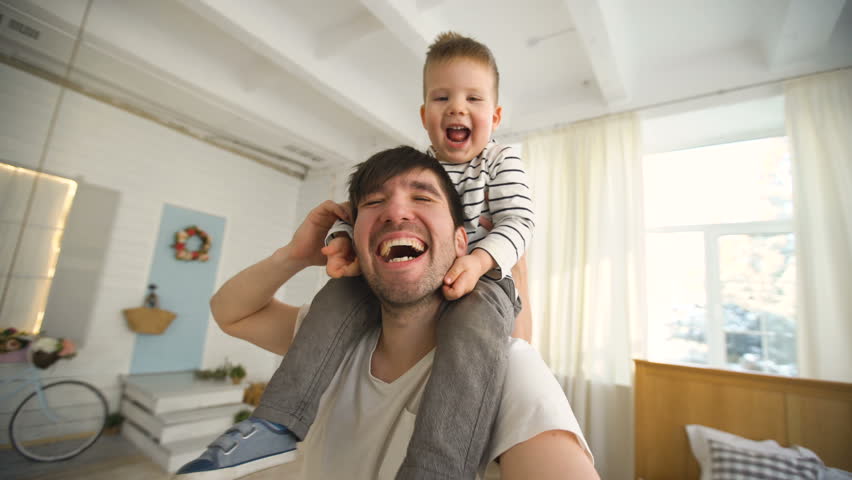 Happy father carrying his smiling son on neck and making selfie on video in bedroom Royalty-Free Stock Footage #23985370