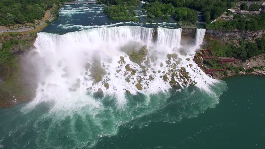 Niagara Falls aerial view, Maid of the Mist tour boat passing in front of American Falls, one of three waterfalls that together are known as Niagara Falls, on the border of US and Canada.