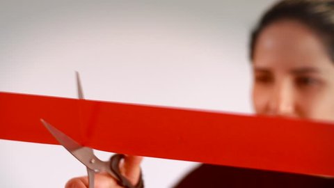 Confidant business woman cutting red ribbon