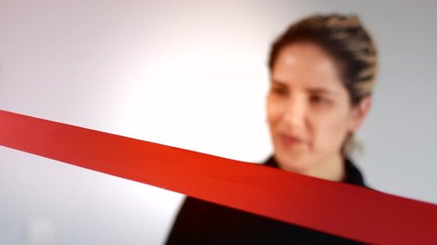 Smiling woman cutting red ribbon