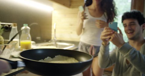 Pancake flip Friends making home Made food taking photo using phone sharing on social media