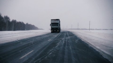 ALTAI REGION, RUSSIA \x96 JANUARY 21, 2017: Driving along the Russian route M52 (R256) in winter blizzard. Vehicle POV.