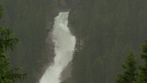 Slow tilt down on a portion of the Krimml Waterfalls in Salzburgland, Austria, on a rainy day.