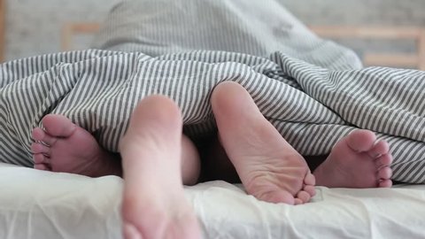 Close up of couple legs have sex in bed, sex movement (making love or sex concept)