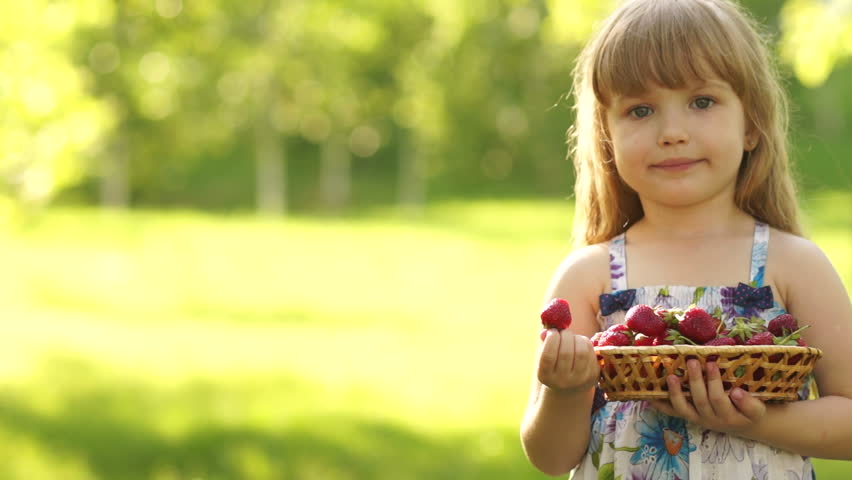 Portrait of a smiling child eating strawberries
