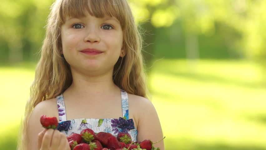 Laughing child eating strawberries
