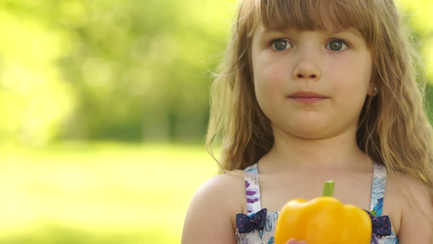 Close-up portrait of girl holding vegetable in hands