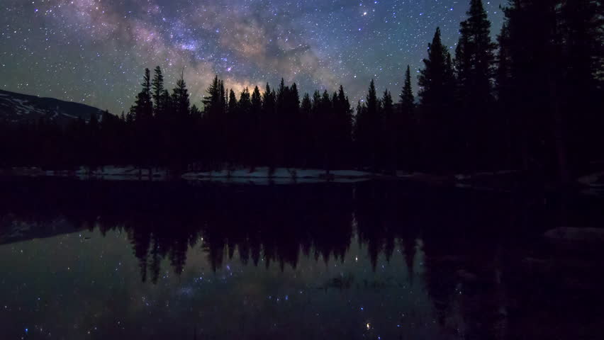 Astrophotography time lapse of milky way galaxy over reflective alpine lake in Yosemite National Park, California -Long Shot-
