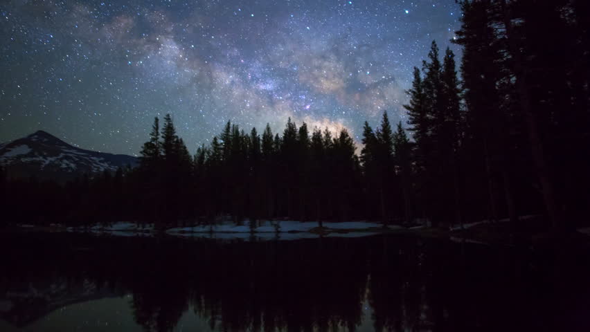 Motion controlled astro time lapse with pan right motion of milky way galaxy over alpine forest in Yosemite National Park, California