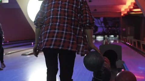 Friends playing and having fun at bowling game HD leisure video. Young man and woman rolling ball throwing to lane. Hobby and competitions
