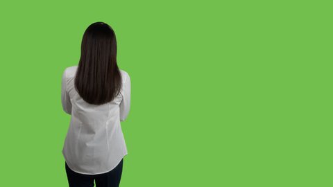 Rear view of woman in white shirt looking at something against green screen. 4k footage PNG with alpha channel