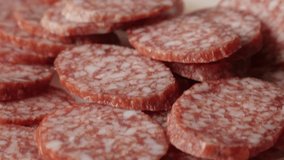 Smaller pieces of salami on table 4K 2160p 30fps UltraHD tilting footage - Food background of cured sausage of air-dried meat cuts slow tilt  3840X2160 UHD video