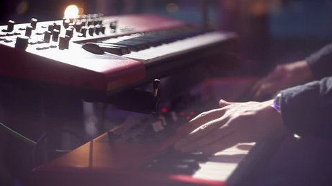 The musician playing the electric piano, Electric piano, Actor playing on the keyboard synthesizer piano keys. Musician plays a musical instrument on the concert stage. synthesizer, press the keys,