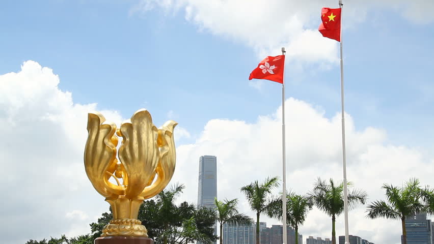 Statue of the Golden Bauhinia with China and Hong Kong flags flying - The statue