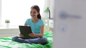 people, children, communication and technology concept - happy girl with tablet pc having video chat and showing thumbs up at home