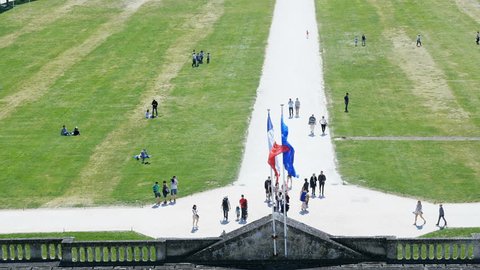 Chambord, France - Circa 2016: Elevated view from a still drone of people entering the Chateau de Chambord with flags of France and the European union waving on a warm summer day