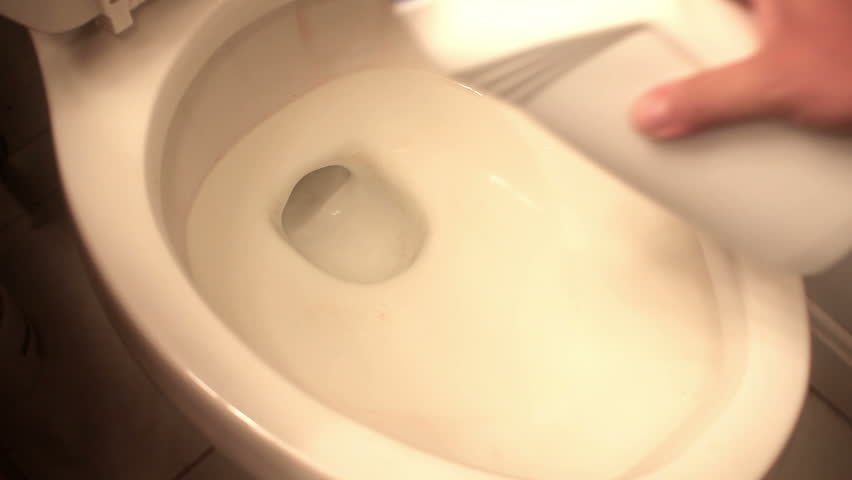 Cleaning a toilet bowl.