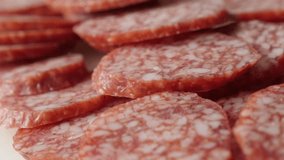 Dry  salami pieces on plate food background slow pan 4K 2160p 30fps UltraHD footage - Cured sausage air-dried meat cuts pile 3840X2160 UHD panning video
