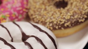 donuts with different fillings on the wooden table. video rotation