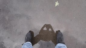 Black roller blades on legs of riding man and wet asphalt, mobile phone video.