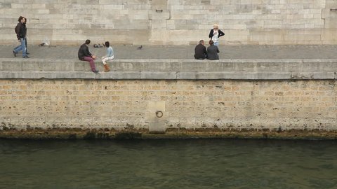 PARIS, FRANCE APRIL 8th: People on the banks of the Seine on April 8th, 2012. The Seine is a 776 km long river and an important commercial waterway within the Paris Basin in the north of France.