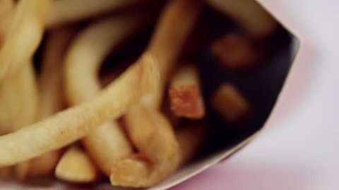 Closeup shot of fast food fries falling in slow motion