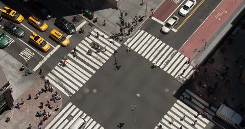 Bird's eye view of a busy intersection in Midtown Manhattan. Looking down on the streets of New York. Yellow taxis, city buses, cars, and people cross through the intersection going to work,timelapse.