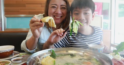 Happy asian family mother and son enjoy eating 