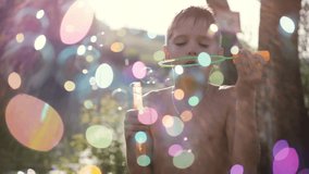 Young handsome happy boy blowing bubbles outdoors on sunny day in summer on sunshine background with blurred magic bokeh. 1920x1080 - Powered by Shutterstock - Get 15% off with code: PIKWIZARD15