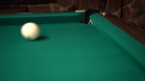 Ball rolling on a billiards table and missing a pocket