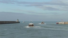 Commercial fishing boats leaving the port. Fisherman boats on the azure waves in Dieppe, Normandy. Real time video in sunny day.