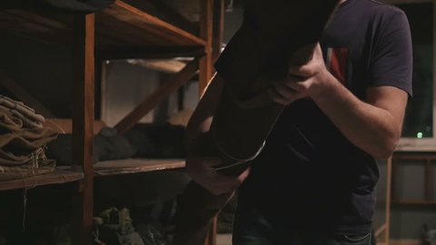 Man taking big roll of leather at the workshop, slow motion